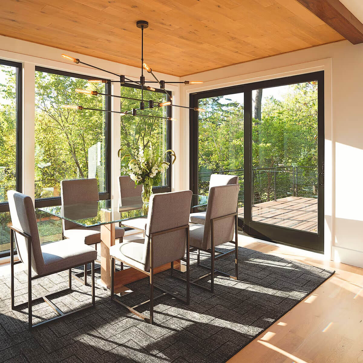 Sunlit dining room with a wall of Renewal by Andersen windows and patio doors